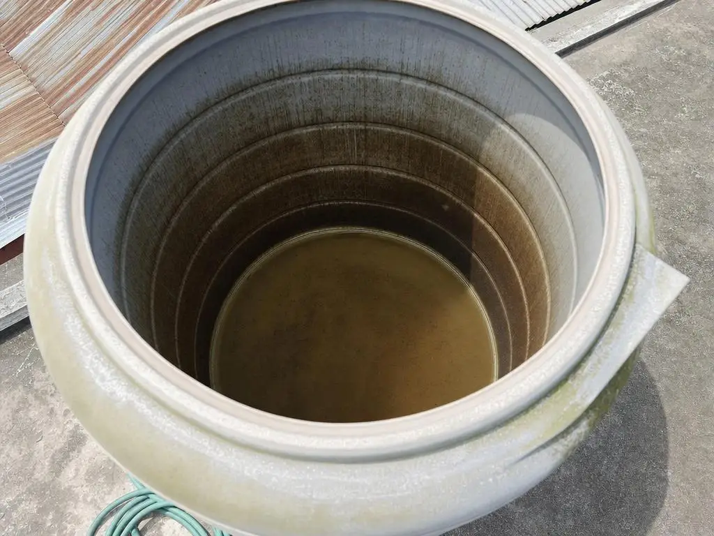 Bagian dalam toren dilihat dari lubang atas, endapan cokelat terlihat di dasar dan air keruh