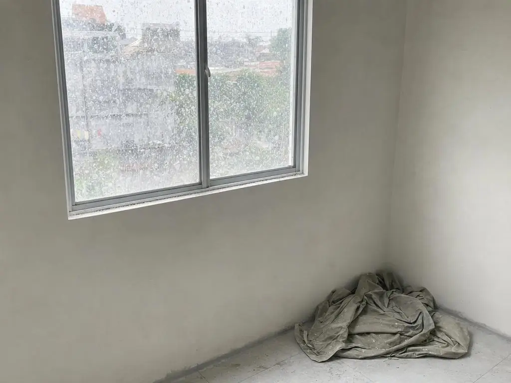 Kaca jendela baru berlumur bercak cat putih kering dan kabut semen